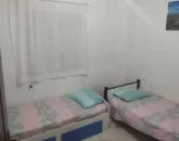 دو تخت خواب با روتختی صورتی و پرده سفید در اتاق خواب ویلا در گرگان