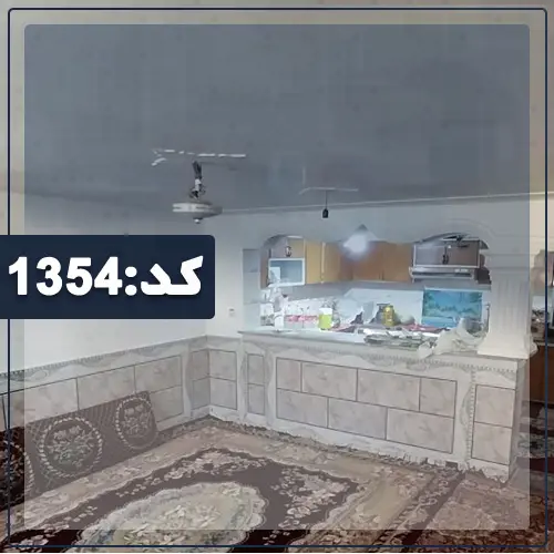 فرش و پشتی قرمز و اوپن آشپزخانه در سالن نشیمن خانه روستایی در کلاله