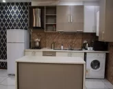 کابینت های قهوه ای رنگ و لباسشویی آشپزخانه آپارتمان در گرگان