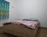 تخت خواب با روتختی صورتی و پرده های رنگی اتاق خواب خانه روستایی در گرگان