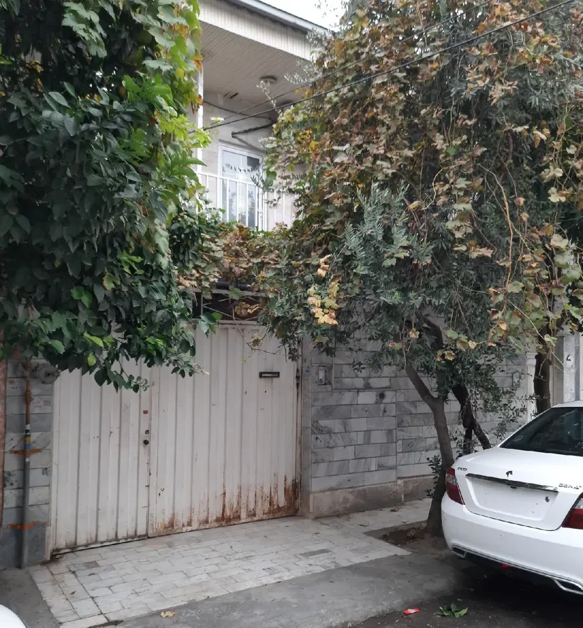 نمای بیرونی درب خانه سفید و درختان سرسبز خانه ویلایی در گرگان 48578454