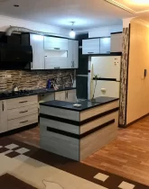 کابینت های قهوه ای رنگ و یخچال و هود آشپزخانه آپارتمان در رامیان