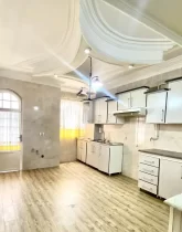 کابینت های سفید و درب رو به تراس آشپزخانه آپارتمان در گرگان