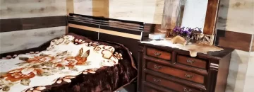 تخت خواب با روتختی رنگی و میز آرایش اتاق خواب خانه روستایی در آزادشهر