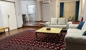 مبلمان کرمی رنگ و جلومبلی و فرش قرمز در سالن نشیمن آپارتمان در بندر ترکمن 54542