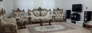 مبلمان کرمی رنگ و فرش قرمز و تلویزیون سالن نشیمن ویلا در گرگان